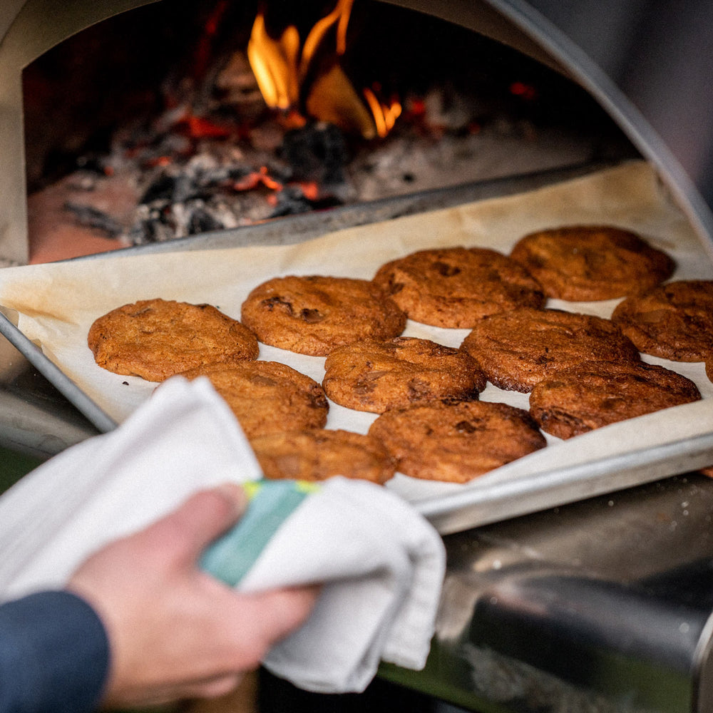 Cooked all butter chocolate chunk cookies being removed from an alfa oven.