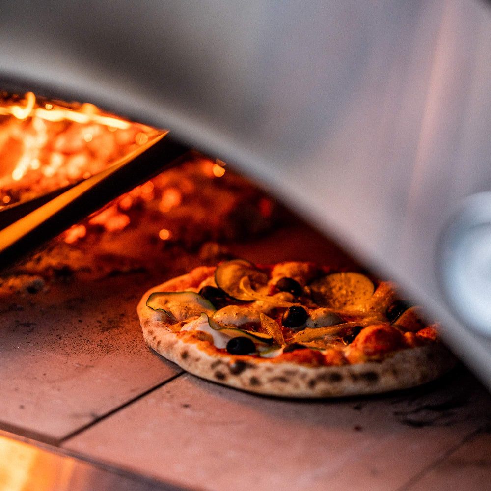 Close up of pizza cooking inside a wood fired alfa oven.